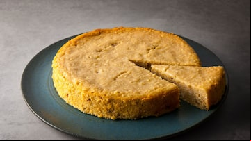 Uma torta de ricota sobre um prato azul escuro em um fundo cinza e uma fatia da torta quase saindo do prato. Foto: Marilia Zylbersztajn/Divulgação